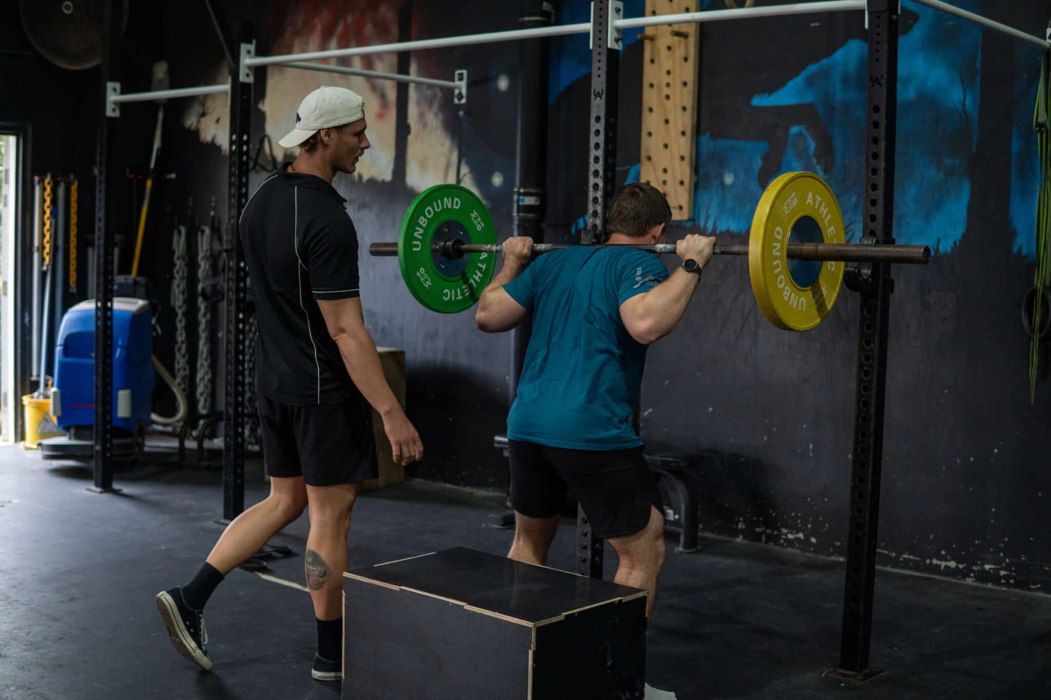 Coach spotting barbell squat